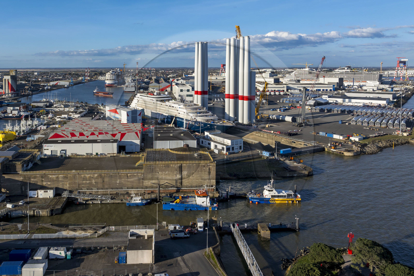 France, Loire-Atlantique (44), Saint-Nazaire, l’écluse Est et l'écluse fortifiée de l'ancienne base sous-marine allemande construite lors de la dernière guerre mondiale au premier plan et le chantier du super-yacht de luxe Ritz-Carlton Luminara dans la forme Joubert, les tours d'éoliennes à droite sont stockées avant embarquement, le paquebot de 333m MSC World America construit par les Chantiers de l'Atlantique en arrière plan (vue aérienne) France, Loire-Atlantique (44), Saint-Nazaire, l’écluse Est et l'écluse fortifiée de l'ancienne base sous-marine allemande construite lors de la dernière guerre mondiale au premier plan et le chantier du super-yacht de luxe Ritz-Carlton Luminara dans la forme Joubert, les tours d'éoliennes à droite sont stockées avant embarquement, le paquebot de 333m MSC World America construit par les Chantiers de l'Atlantique en arrière plan (vue aérienne)