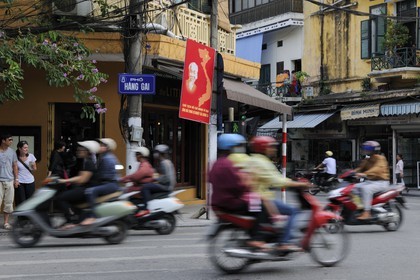 Vietnam, Hanoï, circulation en moto dans la vieille ville sous le regard d' Ho Chi Minh