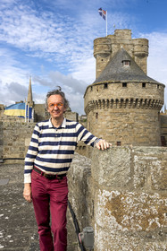 France, Ille et Vilaine, Cote d'Emeraude (Emerald Coast), Saint Malo, the Saint-Malo historian Olivier Chereil de la Rivière, owner of the Magon private mansion, an authentic 18th century corsair residence, the dungeon of the Saint-Malo castle (15th century) in the background