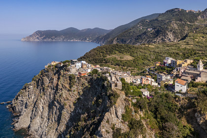 Italie, Ligurie, Cinque Terre, parc national des Cinque Terre classé Patrimoine Mondial de l'UNESCO, le village perché de  Corniglia située au sommet d'un promontoire surplombant la mer Méditerranée à environ 100 m d'altitude, la côte en direction de Monterosso en arrière plan (vue aérienne)