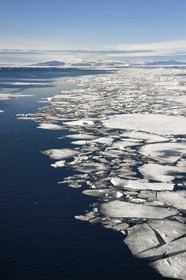 Groenland, cote Nord-Ouest, Smith sound au nord de la baie de Baffin, morceaux de glace de la banquise arctique et iceberg géant en arrière plan vers la côte canadienne de l'ile d'Ellesmere