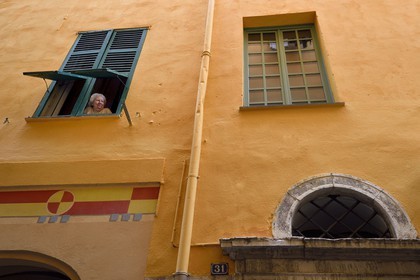 France, Alpes-Maritimes (06), Nice, quartier du Vieux Nice, femme à la fenêtre rue Benoit Bunicau