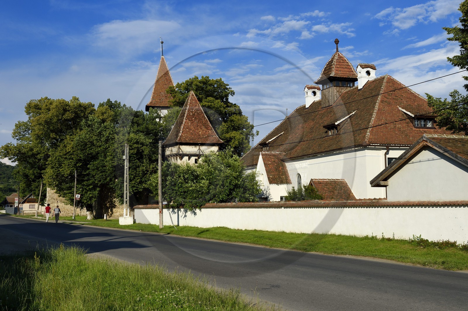 Roumanie, Transylvanie, Cincsor, l'école du village et l'église fortifiée du XIIIème siècle en arrière plan