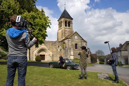 France, Yvelines, Montchauvet, shooting for the television of the Preferred Village of the French (Village Préféré des Français) with Stéphane Bern, Stéphane Bern driving a MG convertible in front of Sainte Marie Madeleine (St. Mary Magdalene) church