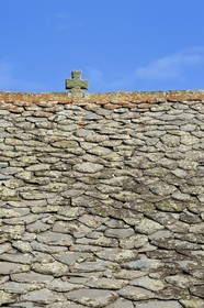 France, Cantal, Parc Naturel Régional des Volcans d'Auvergne (regional nature park of Auvergne volcanoes), step on the Way of St. James to Santiago de Compostela by Via Arverna, Chalinargues, Mons hamlet, the stone cross surmounting the roof of the houses covered with lauze is one of the main traditional themes of protection