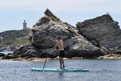 France, Var, Six Fours les Plages, Ile des Embiez, cape Saint Pierre, Freestyle windsurfing champion Adrien Bosson on a paddle boarding excursion, the Grand Rouveau lighthouse in the background