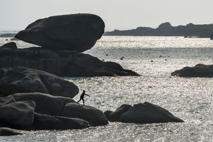France, Côtes-d'Armor (22), Côte de Granit Rose, Trégastel, jeune pecheur à la ligne sur les rochers devant la plage de Ker ar Vir que longe le chemin de Grande Randonnée GR 34