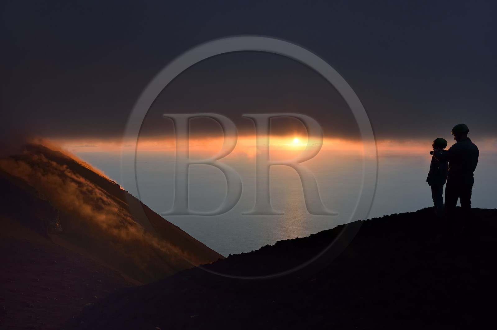 Italy, Sicily, Aeolian Islands, listed as World Heritage by UNESCO, Stromboli island, hikers watching the fumaroles of an eruption on the slopes of the active volcano at sunset