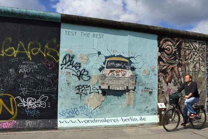 Germany, Berlin, Friedrichshain-Kreuzberg, East Side Gallery, The Wall, work by Birgit Kinder dating from the 1990's, renovated in 2009, representing a Trabant arriving in East Berlin, entitled Test the Best