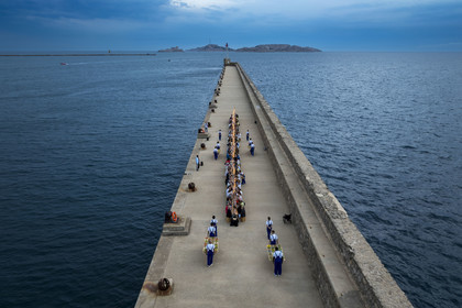 France, Bouches-du-Rhône (13), Marseille, Zone Euroméditerranée, grand port maritime de Marseille (GPMM), la digue du large, convives attablés à une grand table de banquet dressée par le chef Emmanuel Perrodin dans le cadre des Diners Insolites, l’Archipel des îles du Frioul avec le Chateau d'If en arrière plan (vue aérienne)