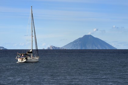 Italie, Sicile, iles Eoliennes, classées Patrimoine Mondial de l'UNESCO, voilier en route pour l'Ile de Panarea au centre et le volcan Stromboli en arrière plan