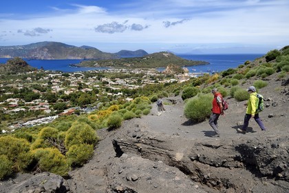 Italy, Sicily, Aeolian Islands, listed as World Heritage by UNESCO, Vulcano Island, hikers on the flanks of the crater of volcano della Fossa, Lipari Island in the background