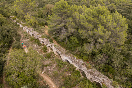 France, Gard (30), Vers-Pont-du-Gard, randonneurs longeant les vestiges de l'aqueduc romain de plus de 52 km de longueur qui amenait l'eau de la Fontaine d'Eure au pied d'Uzès jusqu'à Nimes en passant sur le Pont du Gard  (vue aérienne)