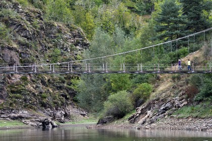 France, Cantal (15), Gorges de la Truyère, Chaliers, deux randonneuses franchissent la passerelle de Valadour au dessus de la rivière Truyère