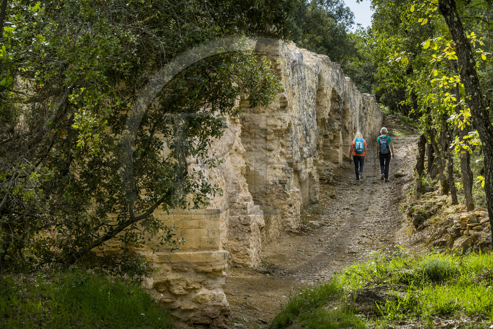 France, Gard (30), Vers-Pont-du-Gard, randonneurs longeant les vestiges de l'aqueduc romain de plus de 52 km de longueur qui amenait l'eau de la Fontaine d'Eure au pied d'Uzès jusqu'à Nimes en passant sur le Pont du Gard
