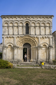 France, Charente Maritime, Echillais, cyclists traveling along the cycle route in front of the 12th century Romanesque church of Notre-Dame, classified as a historic monument