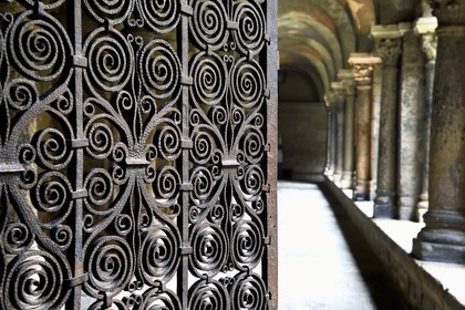France, Haute-Loire (43), Le Puy-en-Velay, étape des chemins de Compostelle, la cathédrale Notre-Dame-de-l'Annonciation du XIIe siècle classée Patrimoine Mondial de l'UNESCO, le cloitre, grille romane en fer forgé réalisée au début du XIIe siècle qui ferme le passage conduisant à la cathédrale