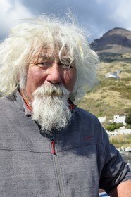 Italie, Sicile, iles Eoliennes, classées Patrimoine Mondial de l'UNESCO, ile de Stromboli, le pecheur Gaetano Cusolito sur la plage de Scari et le volcan du Stromboli en arrière plan
