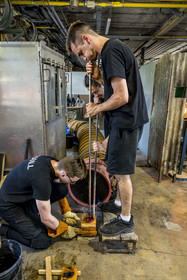 France, Moselle, Meisenthal, Centre international d'Art verrier (CIAV) (international glass centre), the blowing workshop, blowing the Douglas bottle (designed by Francois Azambourg) into a wooden mold by glassmaker Nicolas