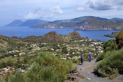 Italy, Sicily, Aeolian Islands, listed as World Heritage by UNESCO, Vulcano Island, hikers climbing the crater of volcano della Fossa, the island of Lipari then Salina island in the background